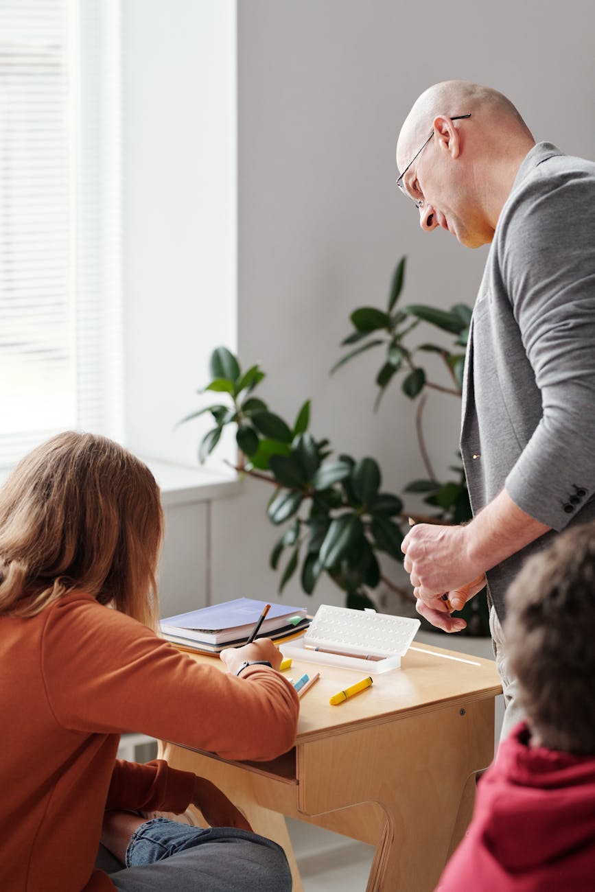 teacher looking at a student writing